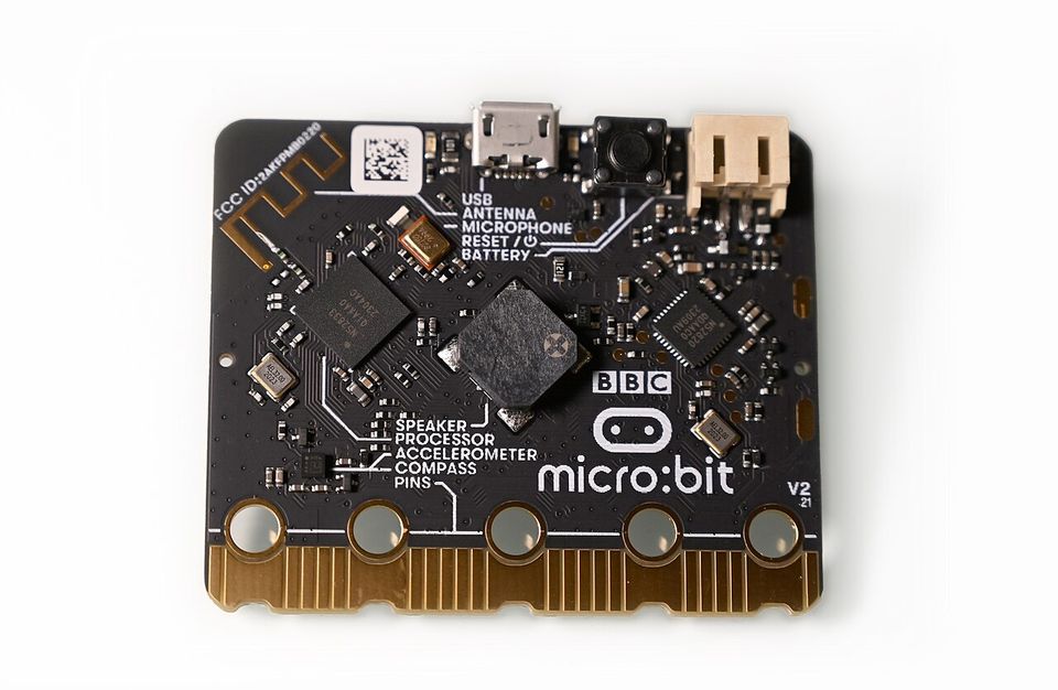 Dos d’une micro:bit V2 : prise USB, bouton reset, prise batterie, haut-parleur au centre, inscriptions des composants et mention V2 en bas à droite.